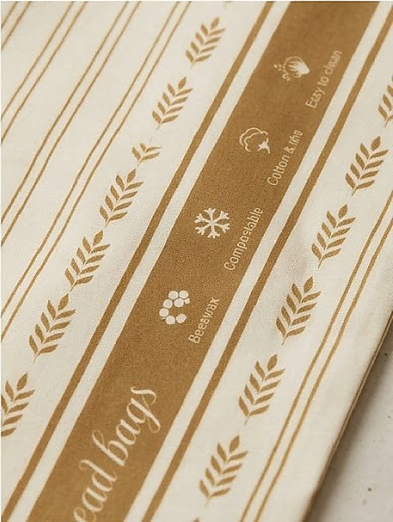 Baumwollstoff mit Bienenwachs und goldenem Ährenmuster im Detail (KI-generiert)